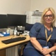 A photo of Kelly sat at a desk