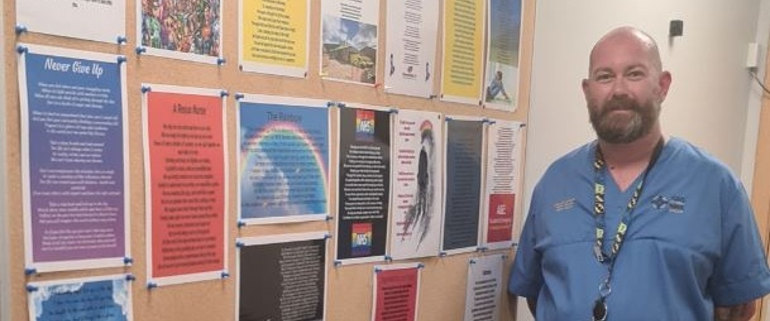 Michael Jenkins stood next to his poetry on display