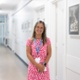 A smiling woman standing in a hospital corridor