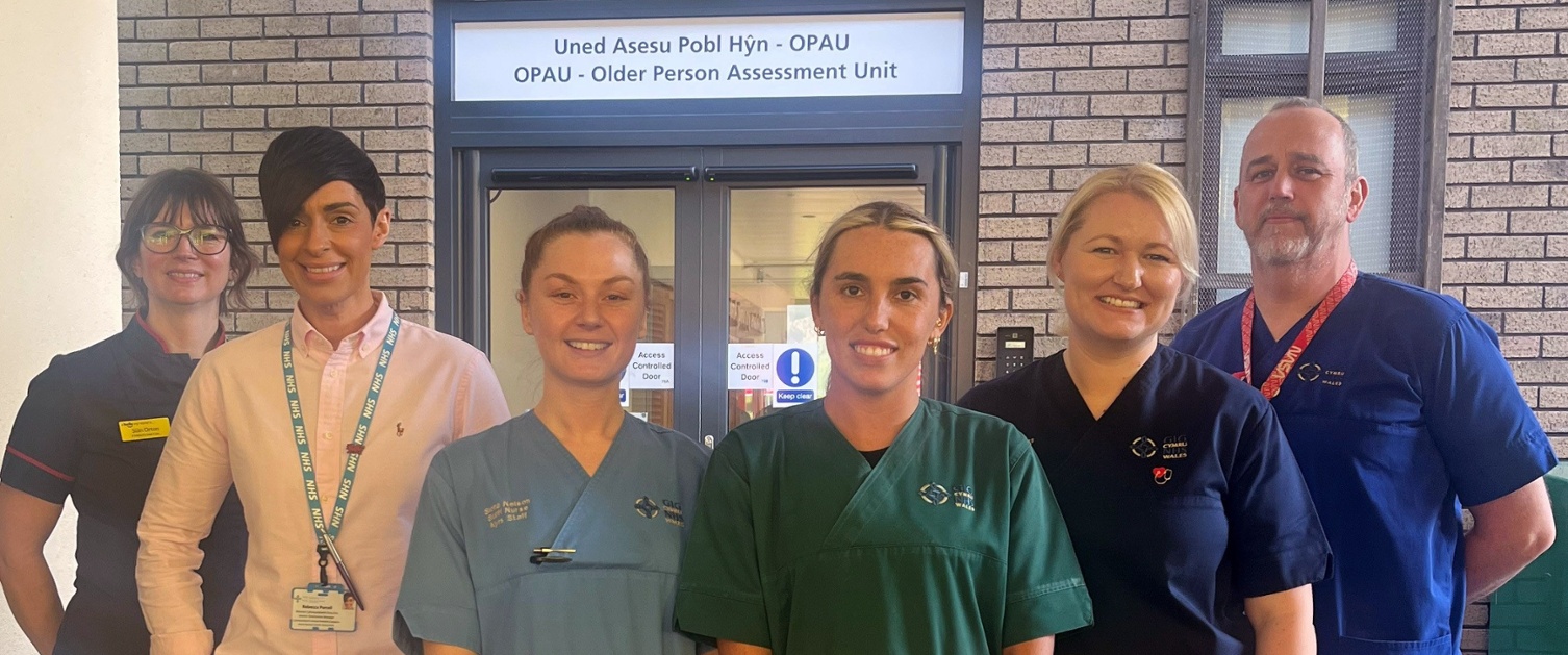 Image shows a group of clinicians standing outside a ward