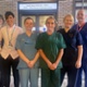 Image shows a group of clinicians standing outside a ward