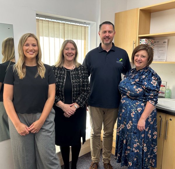 Rebecca, Sharon, Mike and Sarah stood in an office