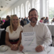 Image shows woman sitting next to a man holding a certificate