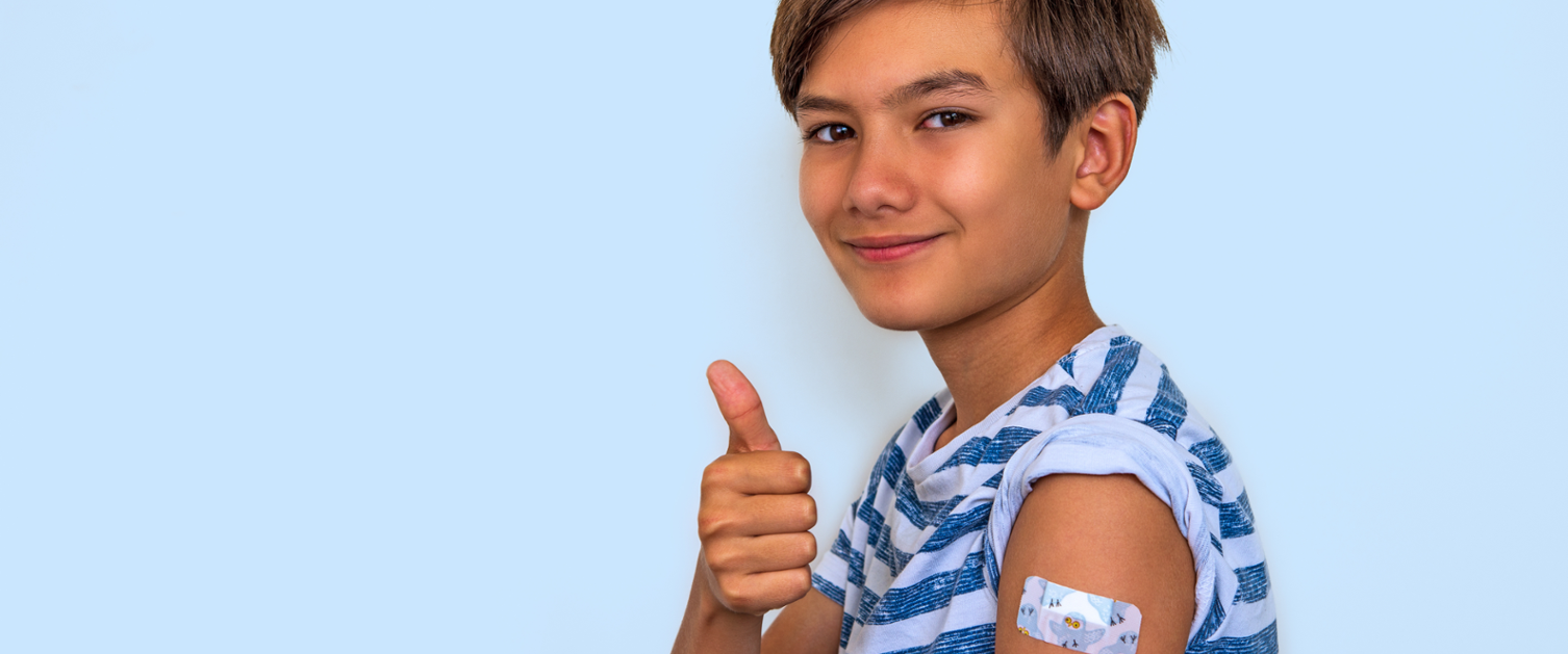 A young boy gives a thumbs up after receiving his vaccination.