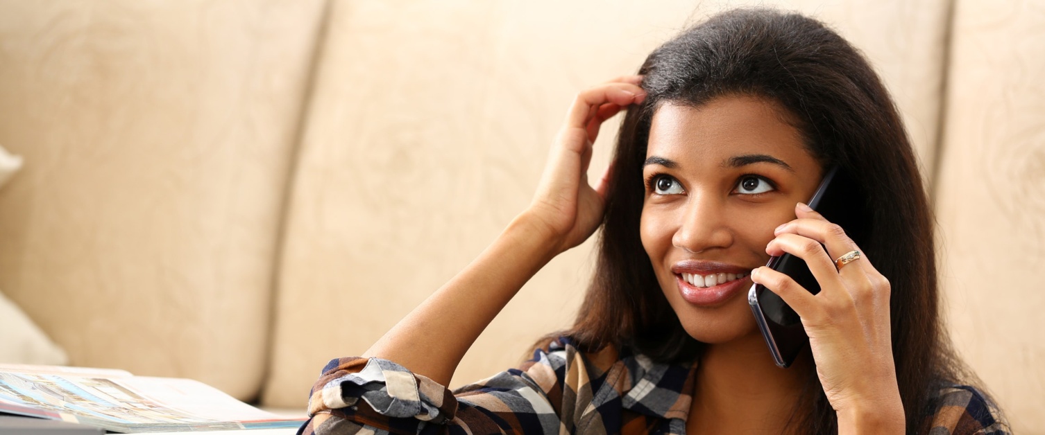 Image shows a woman chatting on a mobile phone and smiling.