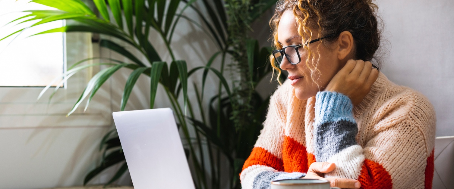 Image shows a woman using a laptop.