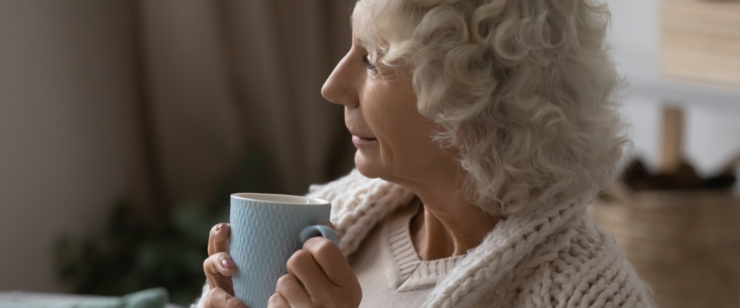 A woman holds a cup of tea.