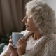 A woman holds a cup of tea.