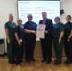 A group of nurses being presented with a certificate