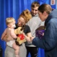 Image shows a women presenting a child with a cuddly toy