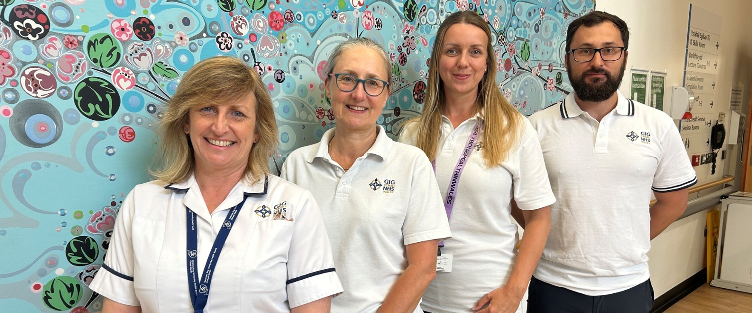 Virtual ward physiotherapists stood in front of a mural