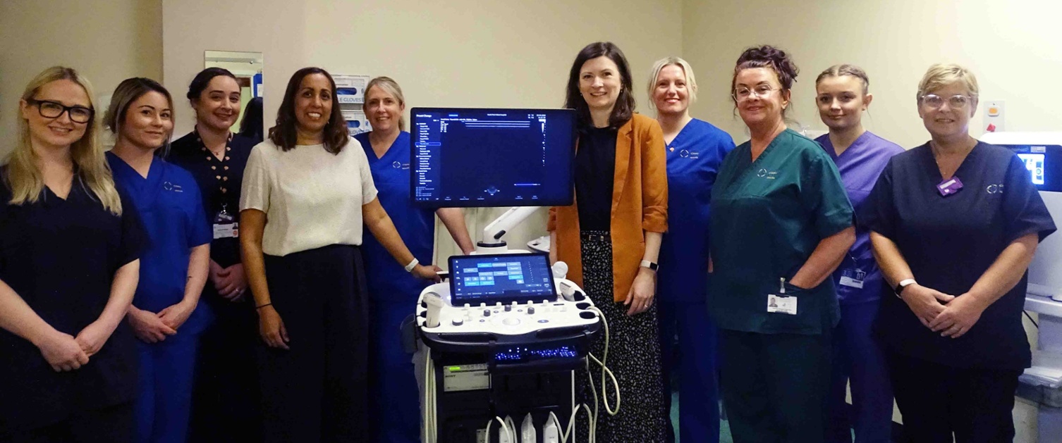 Image shows a group of clinicians with an ultrasound machine.
