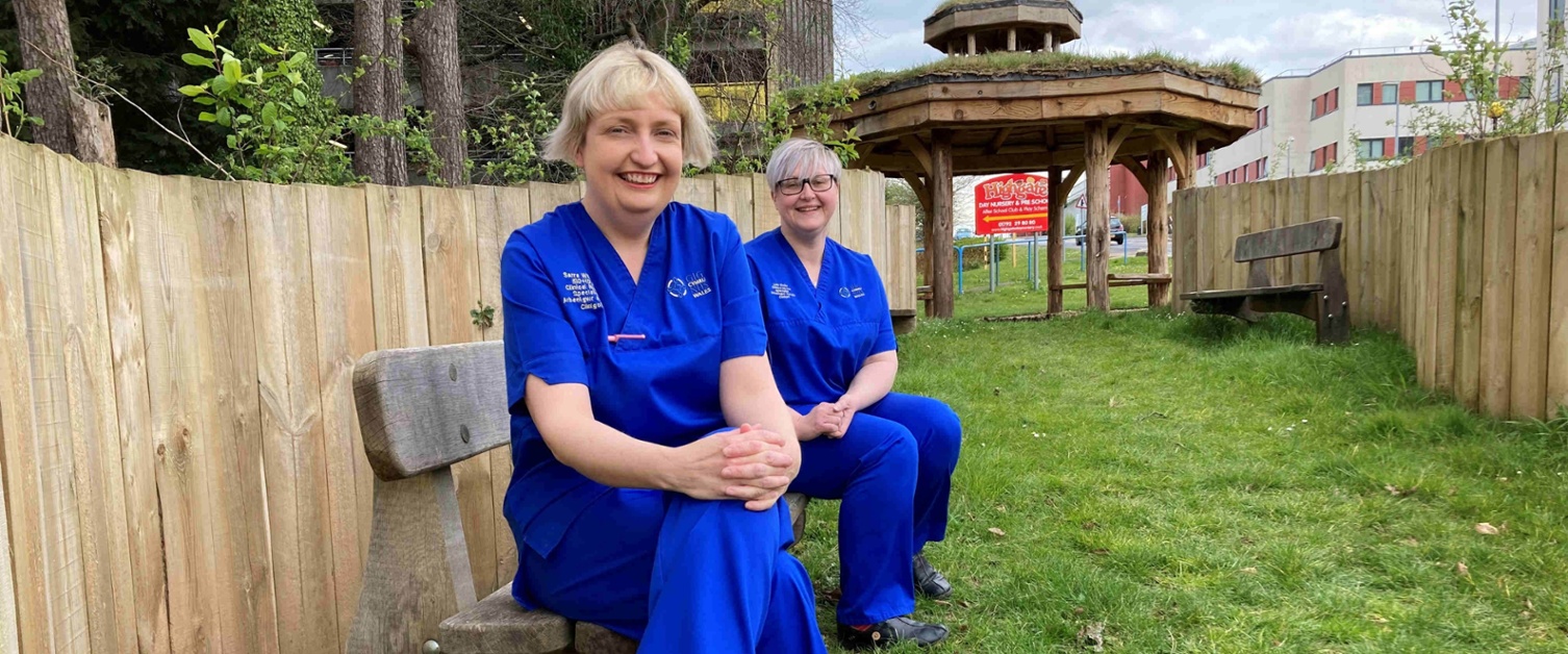 Image shows two women sitting on a bench