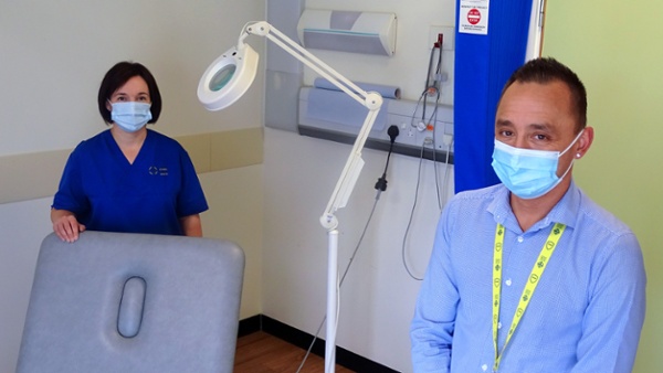 Two people in a hospital examination room