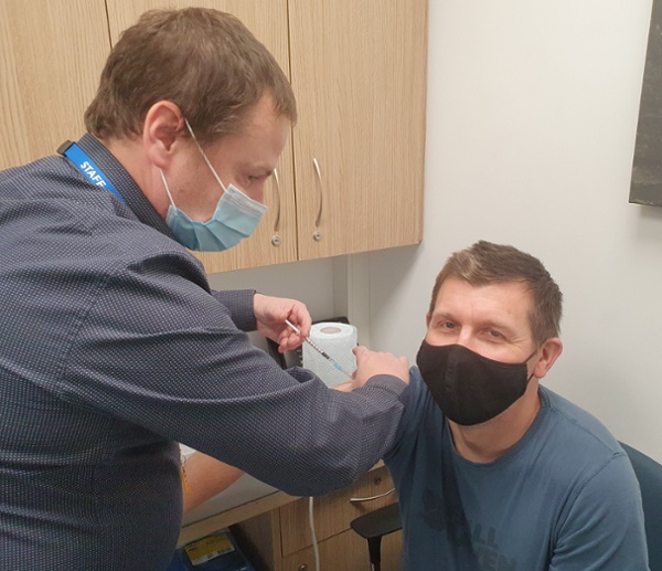 Image of pharmacist administering the flu vaccination to a patient