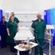 Image shows five staff members stood around an empty bed in a cubicle in the Discharge Lounge.
