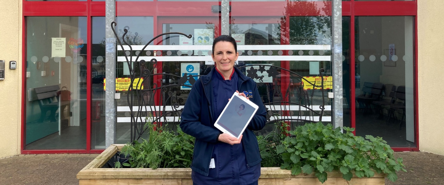 Catrin standing outside a hospital with an iPad