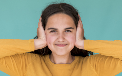 Image shows a person holding their hands over their ears.