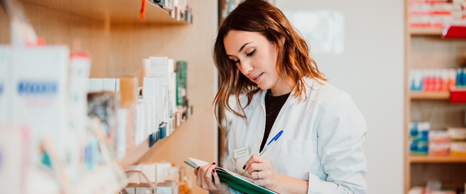 A pharmacist writing in a notebook