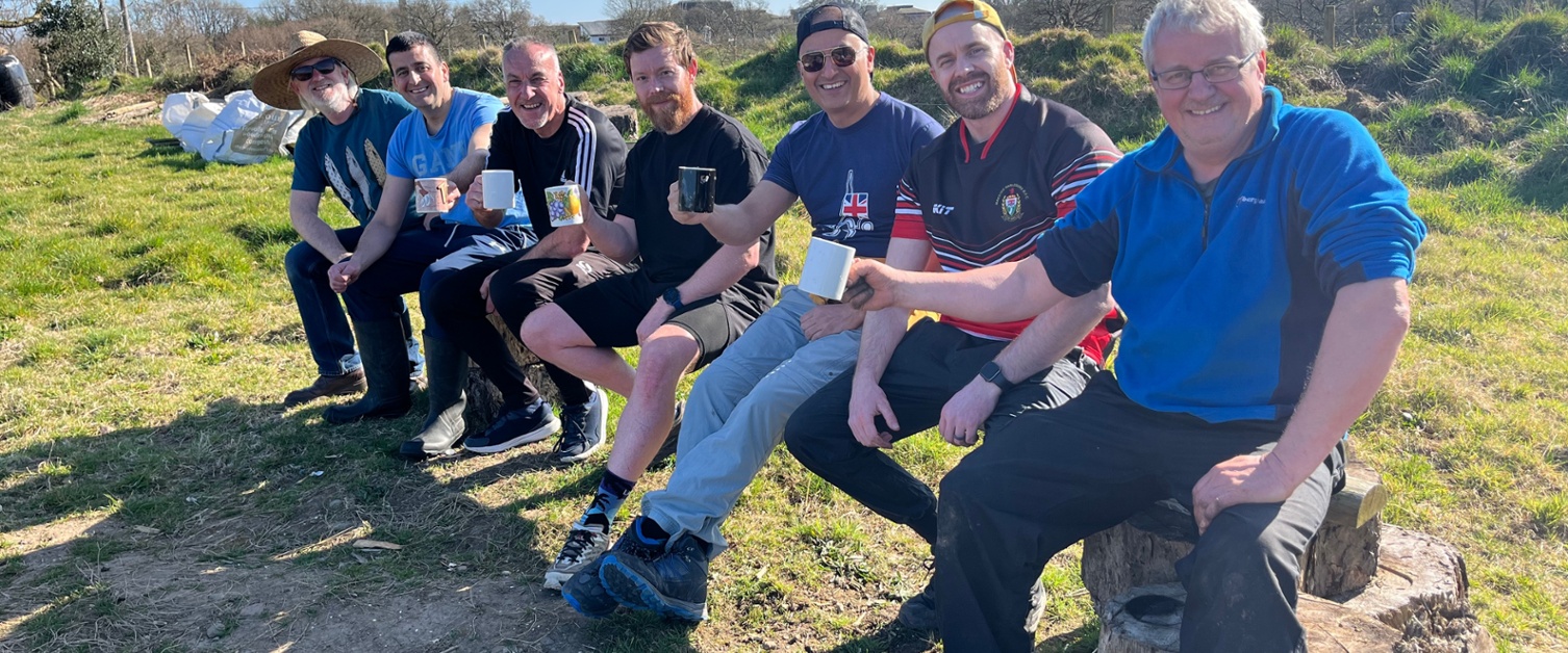 Image shows a group of men having a cup of tea