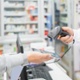 A pharmacist scans a customer