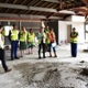 Image shows a group of people inside a building that is being redeveloped.
