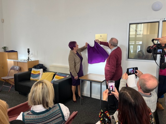 Image shows two people unveiling a plaque