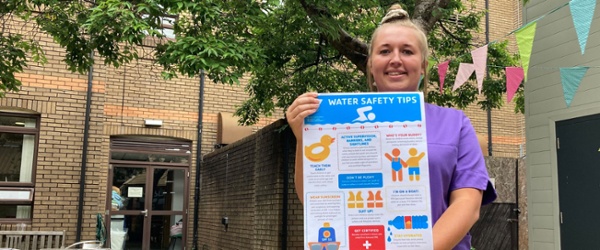 Image shows a woman holding a poster