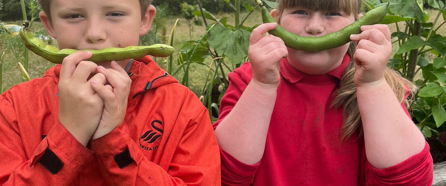 Images show two children holding vegetables in front of their faces