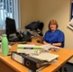 Image shows a woman sat at a desk