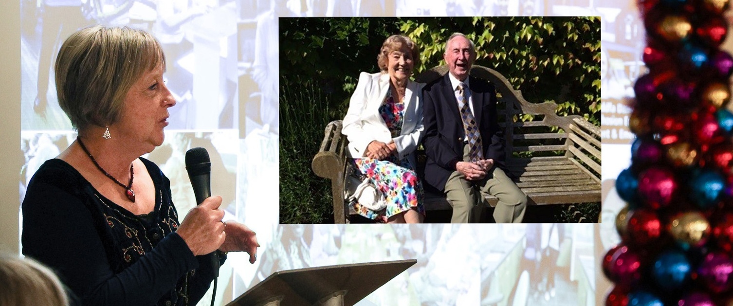 Image shows a woman talking into a microphone alongside a photo of an elderly couple.