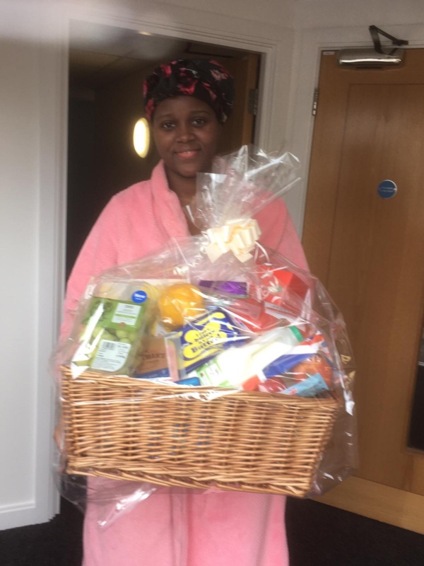 Mum pictured holding a hamper and smiling at the camera.