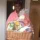 Mum pictured holding a hamper and smiling at the camera.