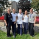 Members of the physiotherapy team stood in front of flowers
