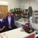 Two women hospital volunteers behind a counter in a shop.