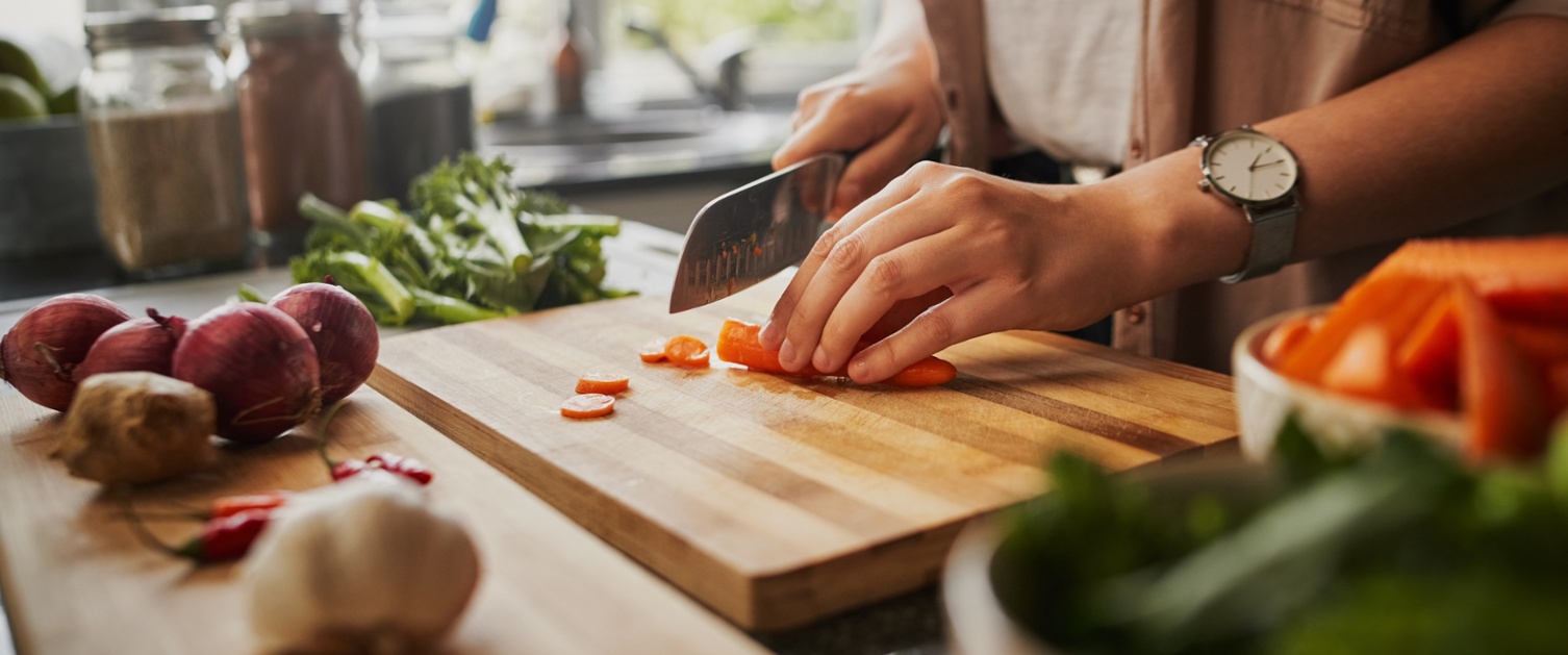 Picture of hands chopping a carrot.