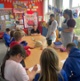Image shows two women talking to children