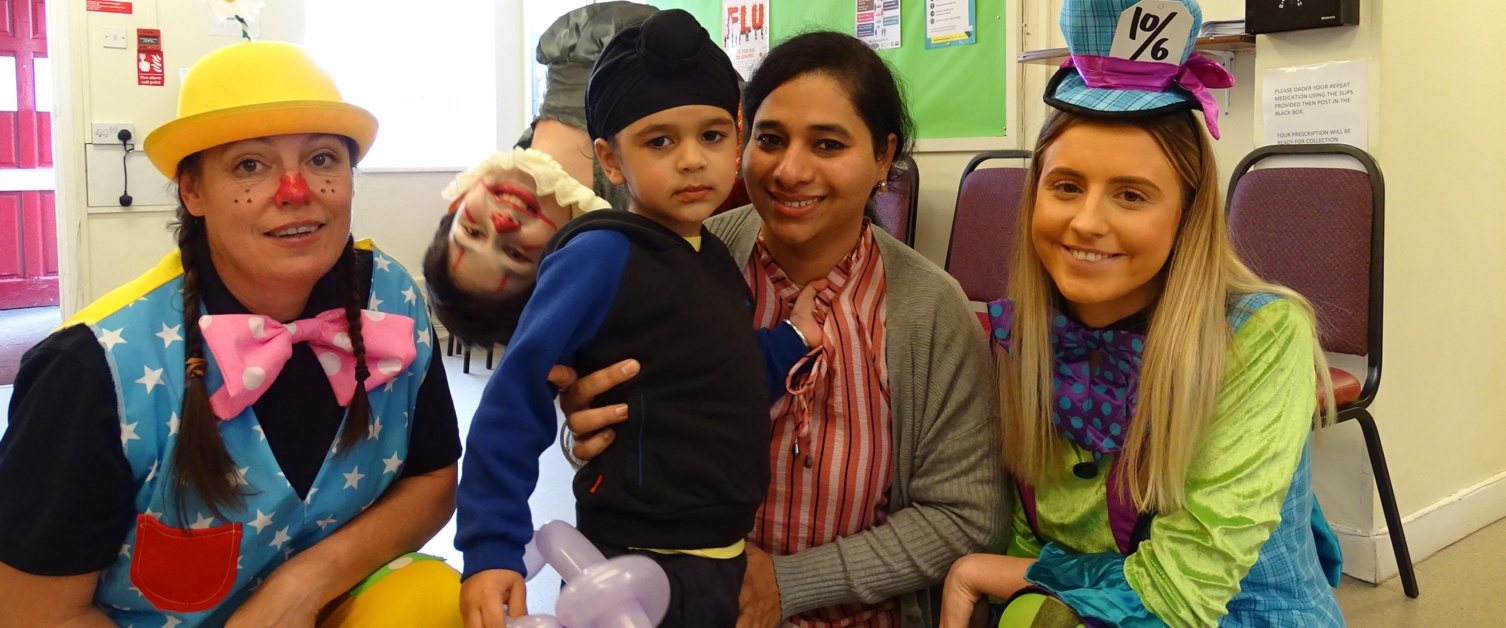 Surgery staff in fancy dress with a smiling mum and son