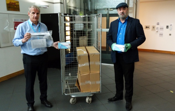 Image shows Mark Parsons holding a face visor in its packet and Mike holding a box of masks