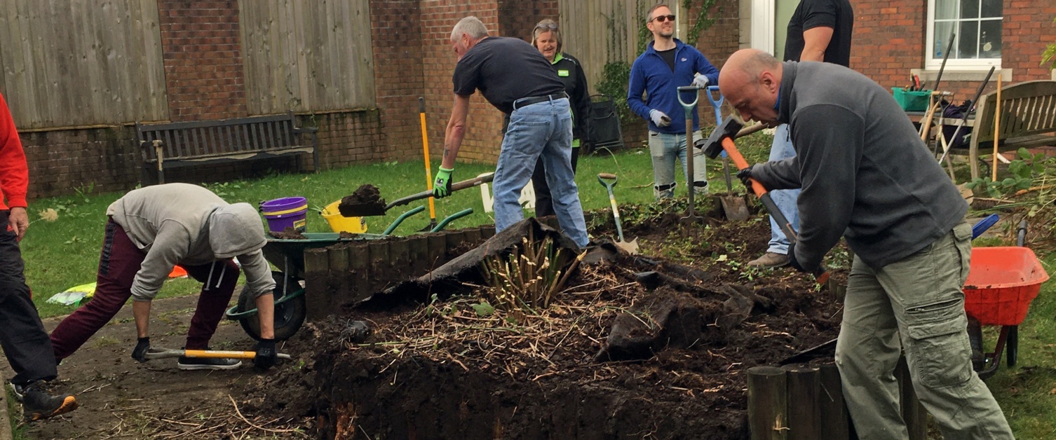 Volunteers take apart a raised flower bed in the grounds of Gorseinon Hospital.