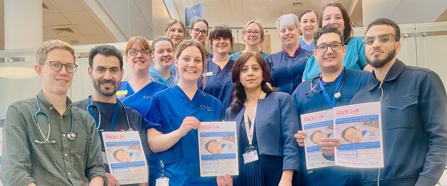 Image shows a group of hospital staff holding posters.