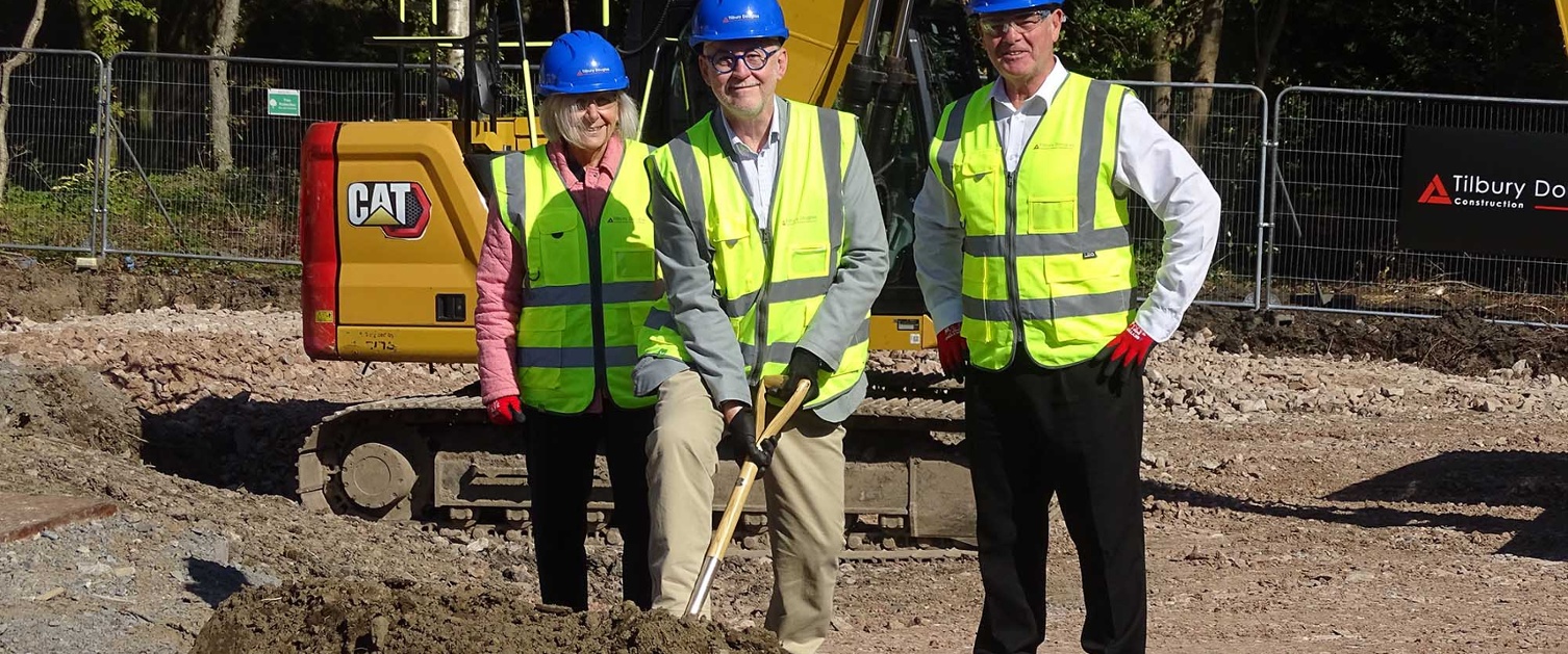 Image shows three people on a construction site.