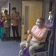 Image shows patient David Courtney-Williams giving the thumbs up to clapping staff.