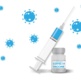 Image shows a syringe leaning against a vial of Covid vaccine.