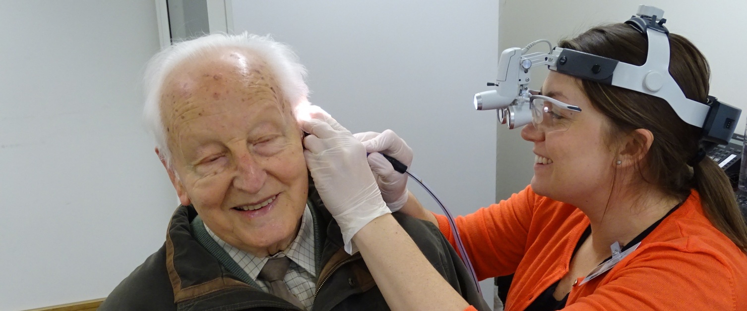 An audiologist checking a patient