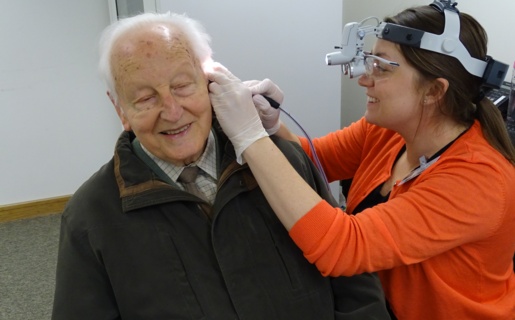 An audiologist checking a patient's ears