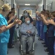 Danny Egan, in a wheelchair, applauds staff who are clapping him