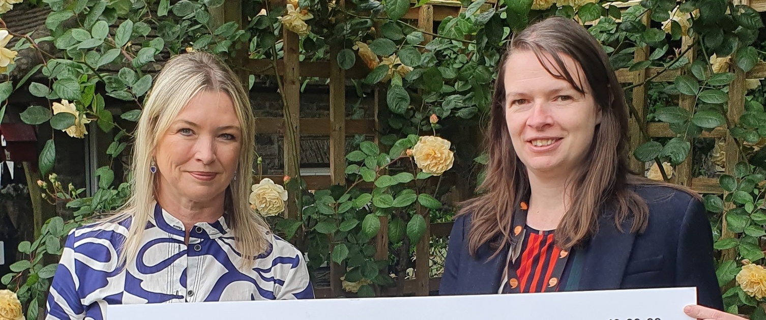 Two women holding a cheque