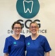 Yvette and Gemma stood in front of the GCG Dental Practice logo