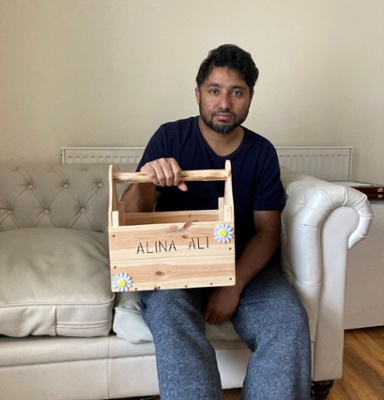 Image shows a man holding a wooden box